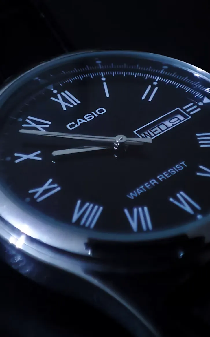 Macro view of a watch dial, hands and applied indices